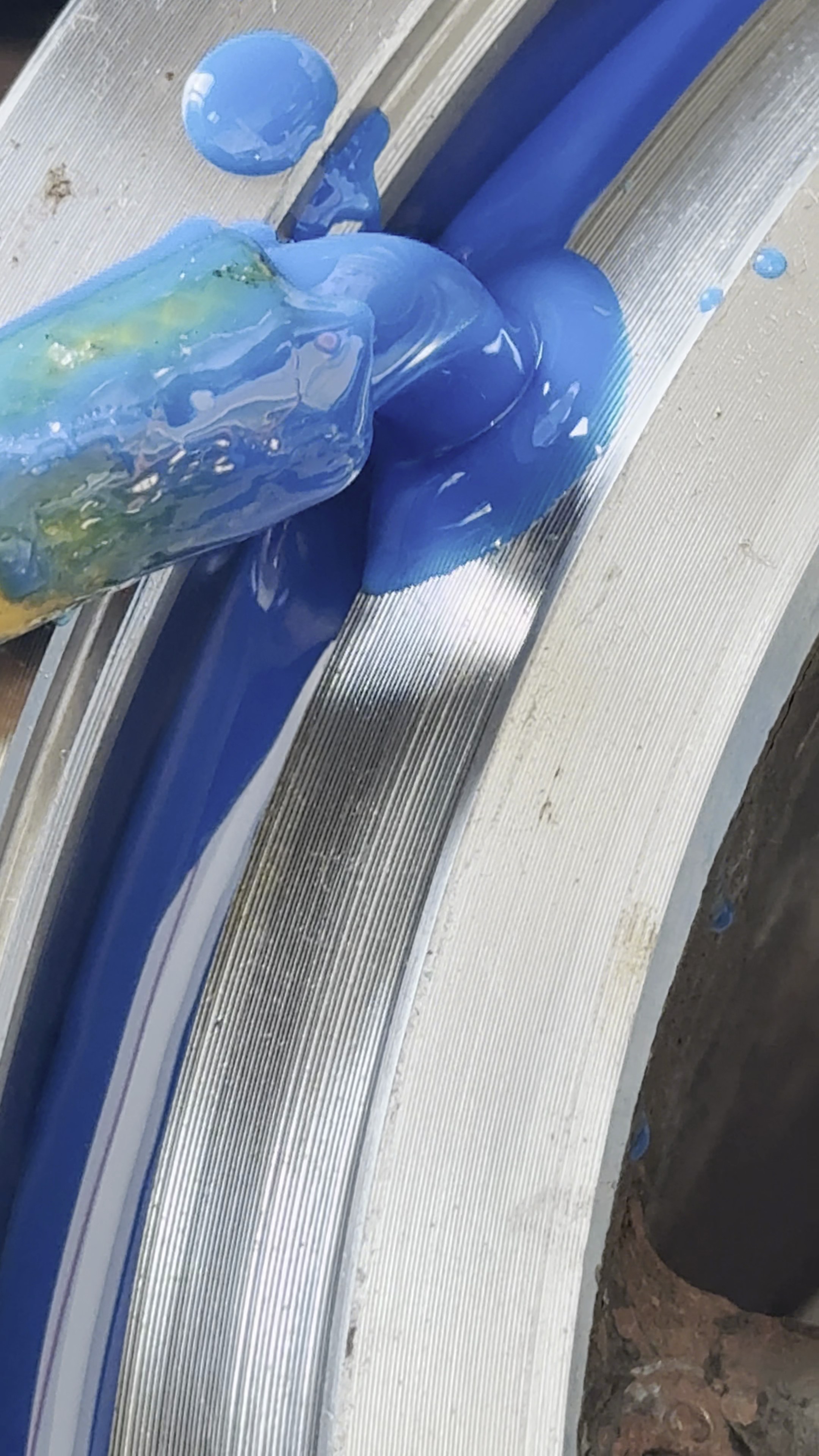Blue polyurethane material being worked into a circular anvil cover mould