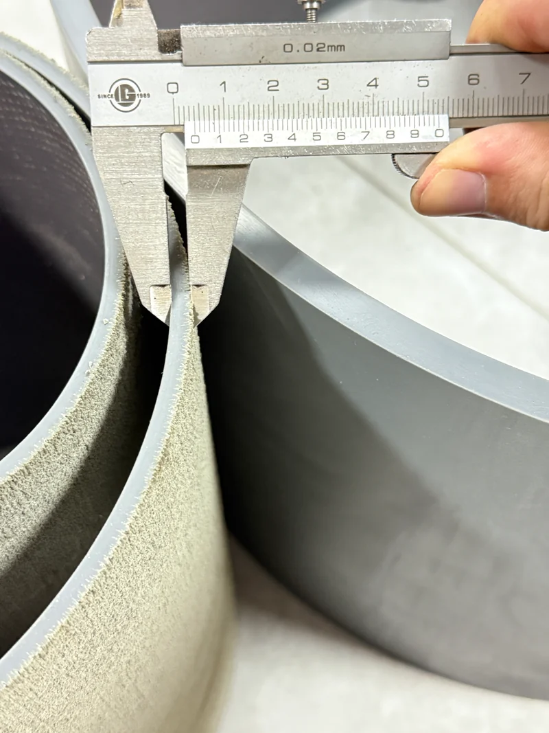 Mordazas de un calibre sobre el borde de una sufridera MDI gris usada con textura